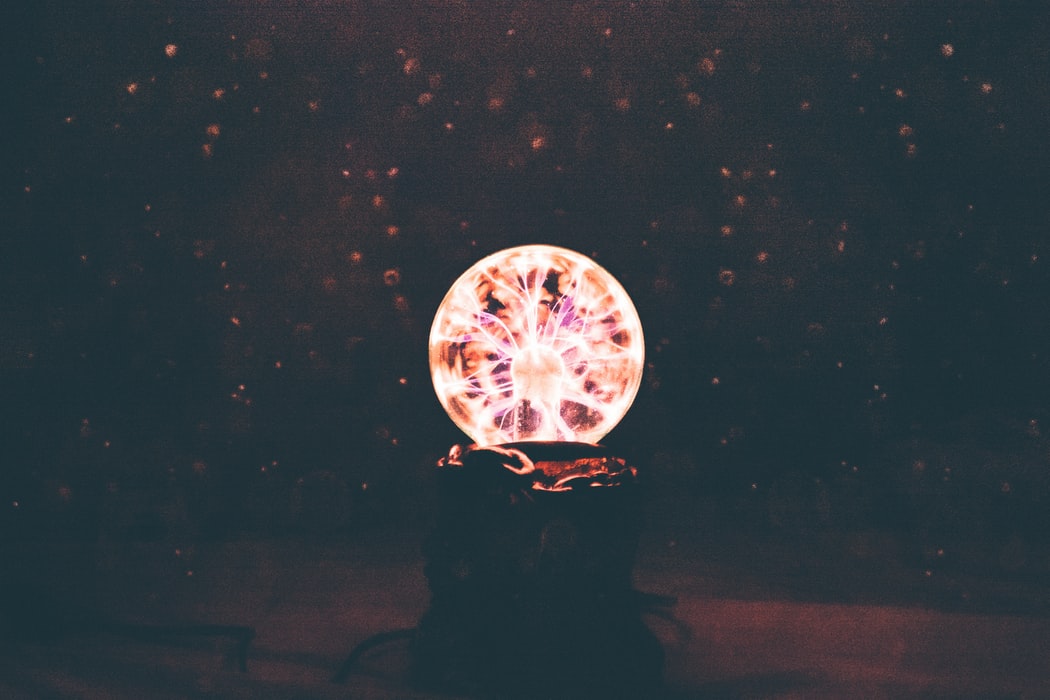 A cristal globe with colorful light inside in a dark room
